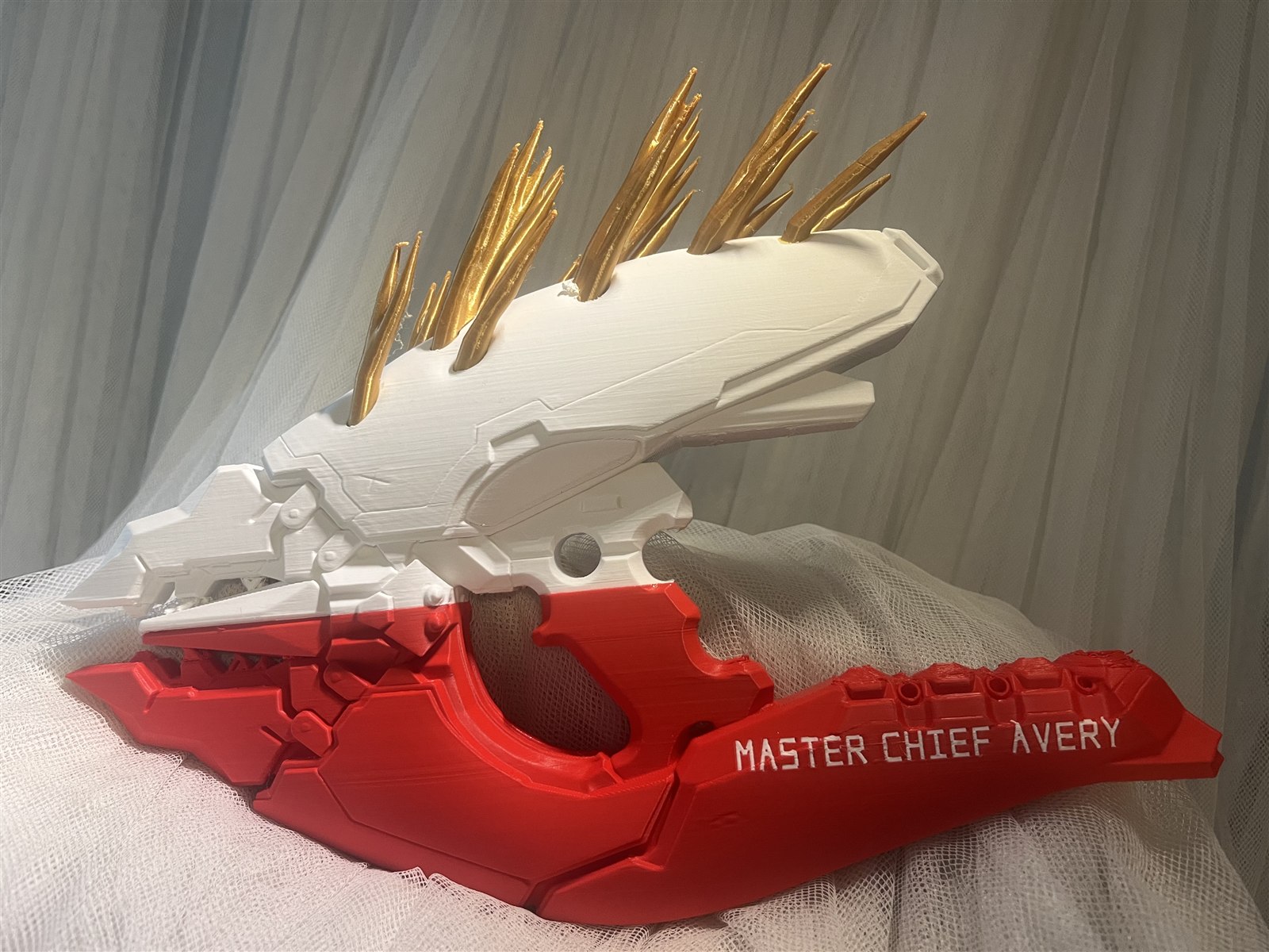White, gold, and red personalized Halo Needler display prop with the name Avery