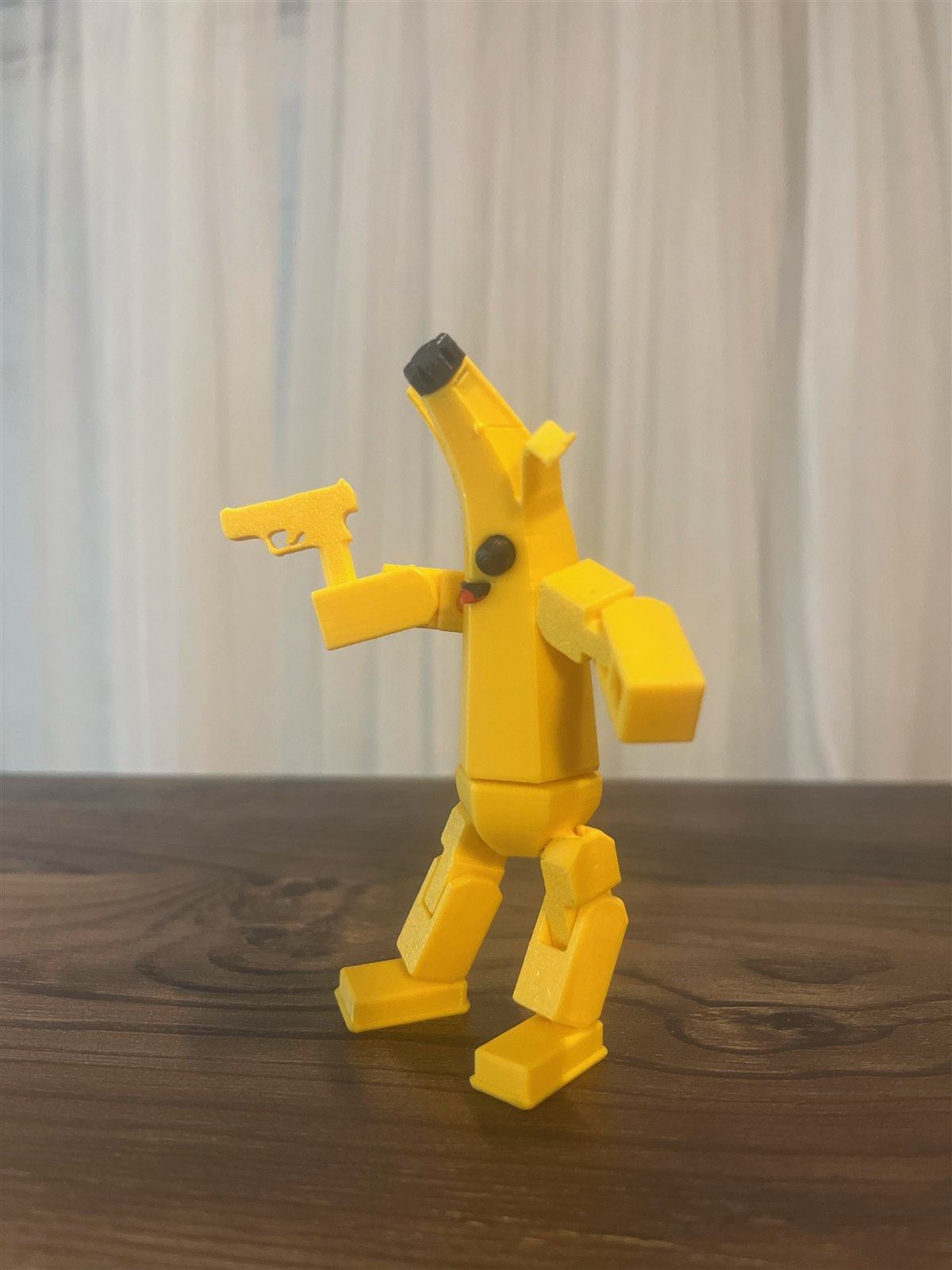 Yellow miniature Peely figure holding a small blaster accessory